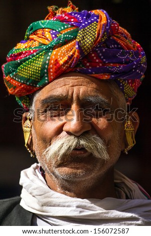 PUSHKAR, INDIA - DECEMBER 1: A Rajasthani man wearing traditional colorful turban posing after Pushkar Camel Fair on December 1, 2012 in Pushkar, Rajasthan, India.