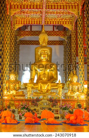 CHIANG MAI, THAILAND - NOVEMBER 18, 2014: Young buddhist monks praying in front of the Buddha image in Wat Suan Dok temple in Chiang Mai, Thailand on 18 November, 2014