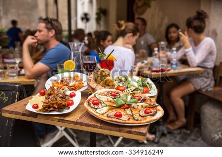 Rome, Italy - September 11, 2015: Unidentified people eating traditional italian food in outdoor restaurant in Trastevere district in Rome, Italy.
