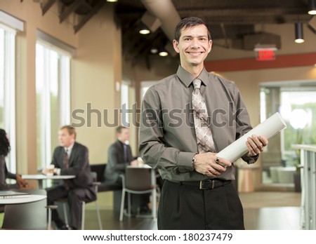 Korean business man in break room holding blueprints and building plans