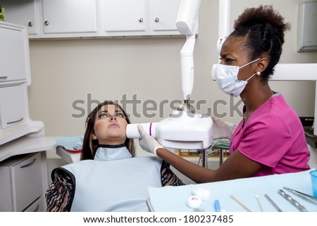 african american dentist or dental tech taking an X-ray during an exam