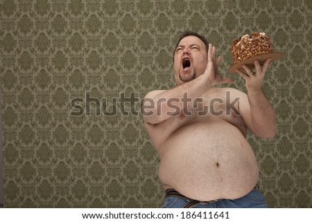 horizontal, color image of an overweight male holding a cake and saying no