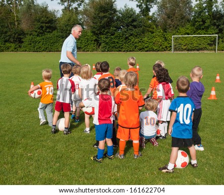 Hillegom, The Netherlands, September 1, 2012: Group Of Small 4 To 6 Year Old Boys And Girls Taking Instruction From A Coach During Soccer Training At The Opening Of The Season.