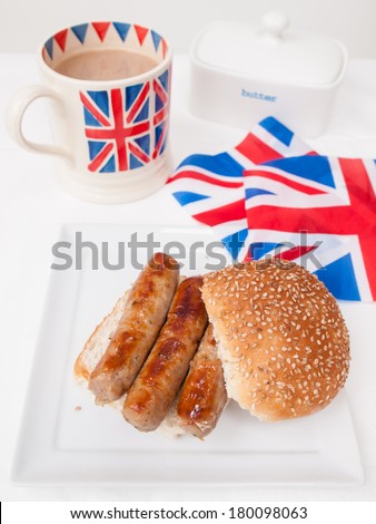 English sausage sandwich with cup of tea in a union jack mug and british union jack flag