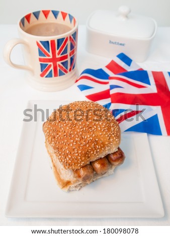 English sausage sandwich with cup of tea in a union jack mug and british union jack flag