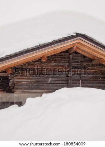 detail of snow covered cabin roof with falling snow
