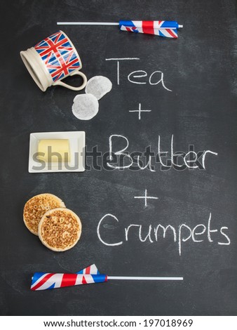 tea butter and crumpets on a blackboard  carrying the words tea butter and crumpets with british union jack flags