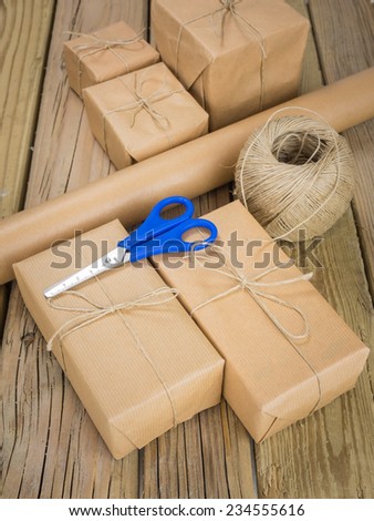 group of brown paper parcels with roll of brown paper string and scissors