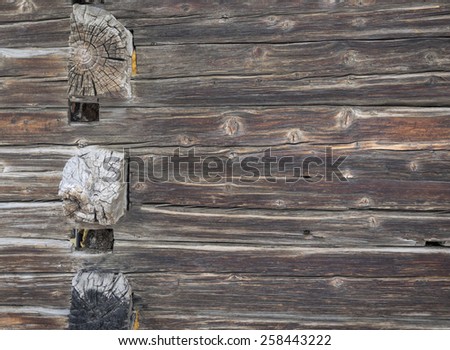 detail of aged weathered cabin wooden wall  with protruding cross beams