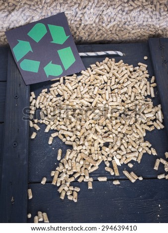 wood pellets in a wood pellet store with recycling symbol behind