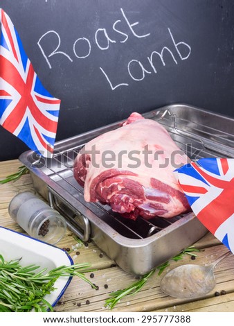 raw  lamb on roasting tin with ingredients for roast lamb and blackboard behind with text roast lamb and british flags