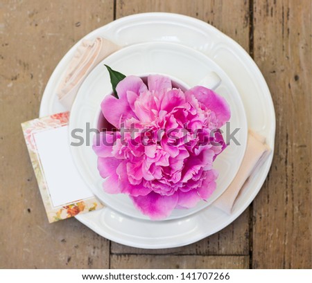 table setting with blooming pink peony. Shallow depth of field