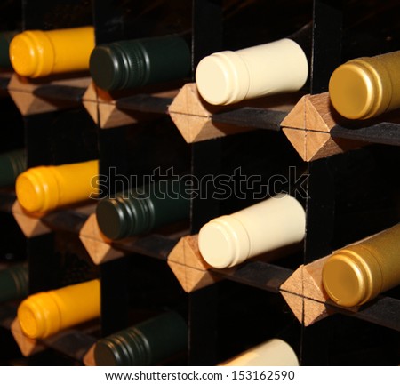 wine bottles stacked on wooden racks. Shallow depth of field