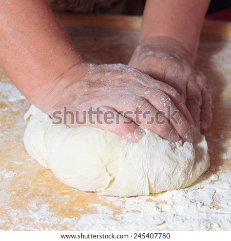 older woman hands knead dough