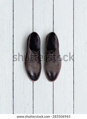 Brown men\'s shoes on a wooden background