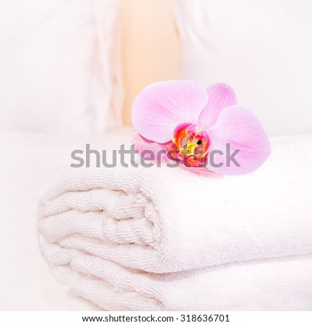 clean towel with orchid on the bed