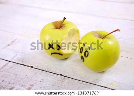 One bitten and another worried apple