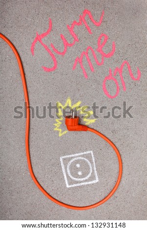 Orange electrical plug-in cable and chalk drawing of electrical outlet and electricity