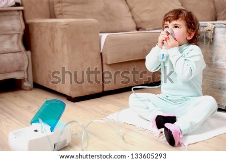 Portrait of a little girl using inhaling mask at home