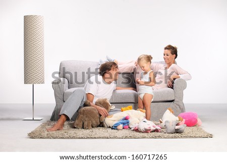 happy family, mother, father and daughter, mom and dad playing with his daughter on the carpet in the living room