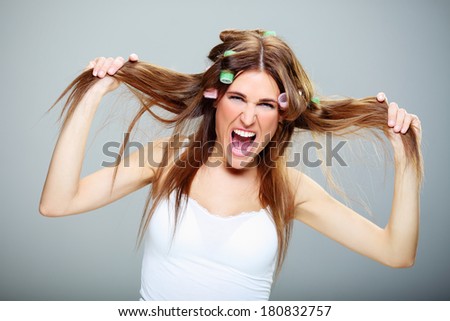 beautiful and cheerful girl with brown hair, hair dressing her  hair with green rollers