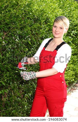 Gardening, trimming hedges, girl trimmed hedge, A young girl working in the garden with a pair of scissors, garden shears with a girl next to hedges,