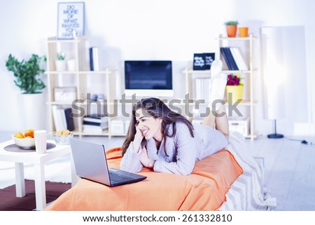 Beautiful woman in bed having coffee, tablet, laptop, computer, phone laughing
