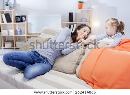 Young mother relaxing with daughter in the living room