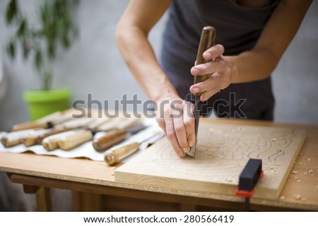 Artist picking cheesel for wood carving,shallow depth of field