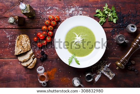 Vegetable soup in a plate on a wooden table, bird\'s-eye view