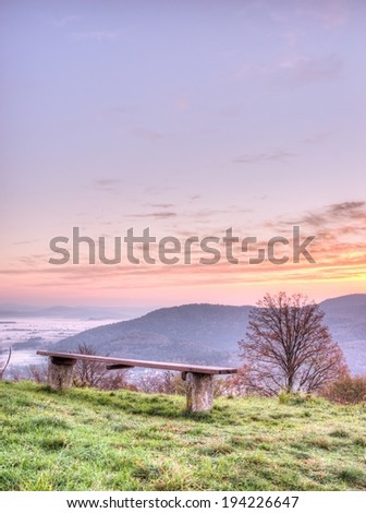 Bench on a hill top with sunrise