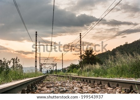 Railroad tracks running towards a setting sun