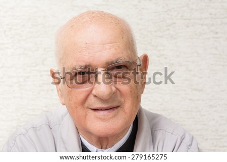 Portrait of elderly man wearing glasses and smiling.