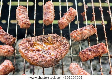 Tasty meat on a barbeque shaped like a sun. Summer grill party.