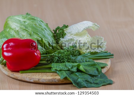 Fresh veggies on kitchen table: Chinese cabbage, green onions, iceberg lettuce, parsley and  red bell pepper