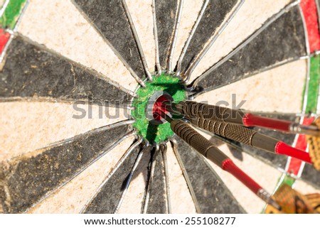 Darts board with three arrows in bullseye