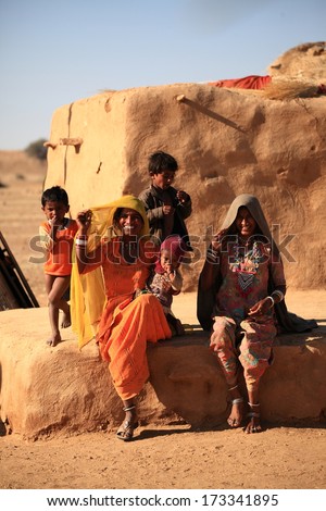 RAJASTHAN, INDIA - FEB 27: Rajasthani family in front of their mud hut on February 27, 2013 in Jaisalmer, India. There are many tribes in Rajasthan with the differences in costumes, jewellery etc.