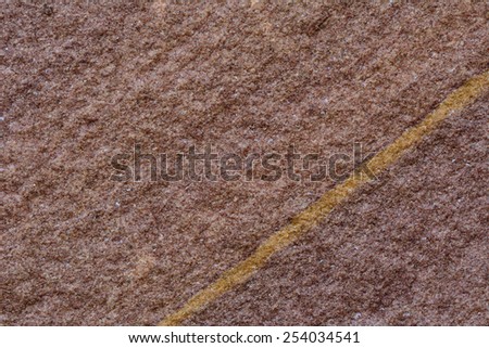 Close of Maroon stone surface with golden line cut through as the great background texture