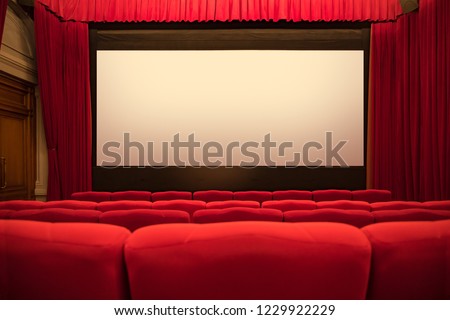 Empty movie theater with red curtains and seats