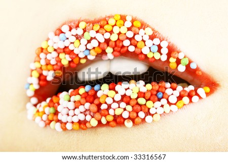 close up of woman tongue and lips with multicolored pearls