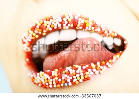 close up of woman tongue and lips with multicolored pearls