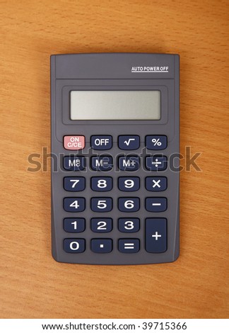 Calculator on wooden desktop.