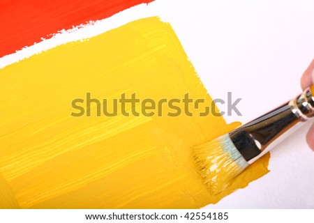 Brush with yellow paint and yellow brush on the white background