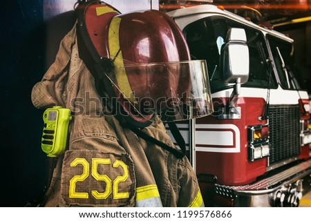 Firefighter helmet, radio and coat in front of the firetruck