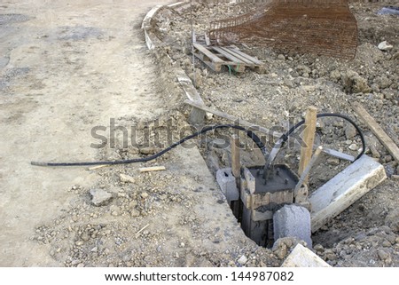 Construction of a light pole foundation.   You can see two lengths of cables because this pole would be in the middle of the loop circuit along that light row.