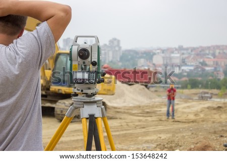 Land surveyors working with total station at construction site