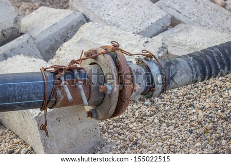Rusty water pump pipe connection joint on the river bank