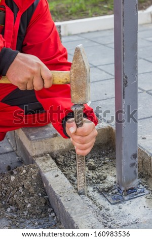 hands with hammer and chisels cleaning mortar, close up of paving work, working on a installation a new hand railing