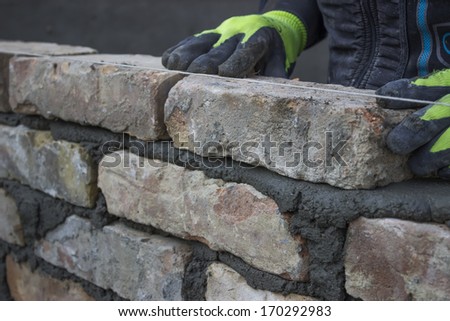 Installing brick, build a brick wall. Bricklaying foundation walls, lay bricks.
