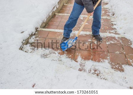 Man shovelling snow from the sidewalk after fresh snowfall